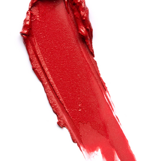 A close-up of a swatch of Karma Matte Lipstick applied to skin, revealing a rich, vibrant red shade with a matte smooth finish.