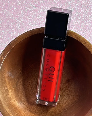 Close-up of a tube Karma Matte Lipstick packaging. Lipstick is a vivid red hue suitable for any makeup look